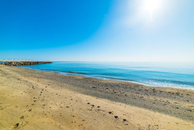 Scenic view of beach against clear blue sky