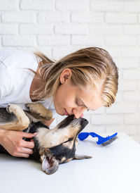 Woman with dog against wall