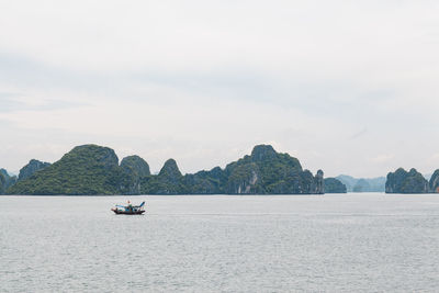 Boats sailing in sea against sky