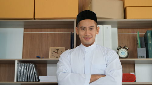 Portrait of young man standing in library