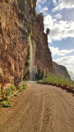 Road amidst rock formation against sky