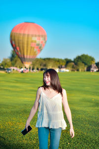 Rear view of woman with hot air balloons against sky