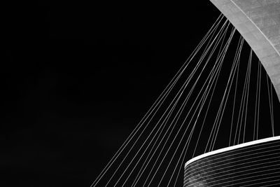 Low angle view of suspension bridge against sky at night