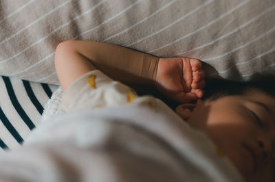 High angle view of baby sleeping on bed