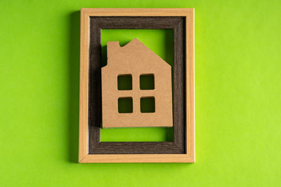 Close-up of toy against green wall of building