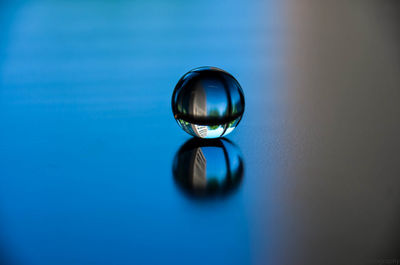 Close-up of blue ball on glass