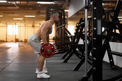 Full length side view of man exercising at gym