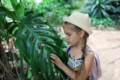 Girl looking at leaf outdoors