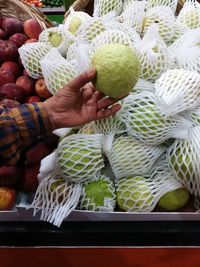 Midsection of woman holding fruits at market