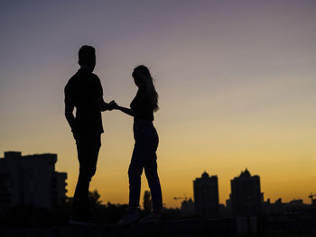 Silhouette couple against sky during sunset