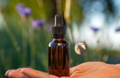 Close-up of hand holding glass bottle