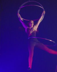 Midsection of woman dancing against black background