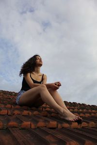 A beautiful woman is sitting on the roof