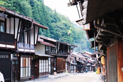 Houses by street amidst buildings in city