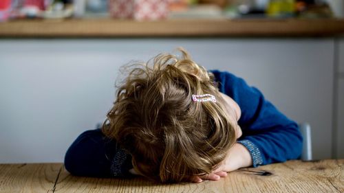 Close-up of girl leaning on table at home