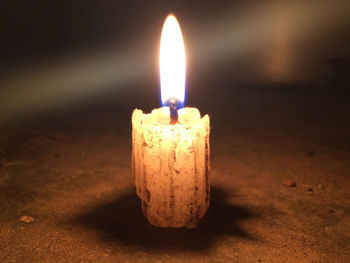 Close-up of lit candle in the dark