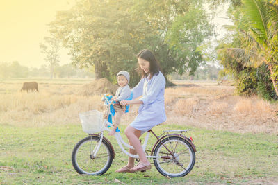 Portrait of woman riding bicycle on field