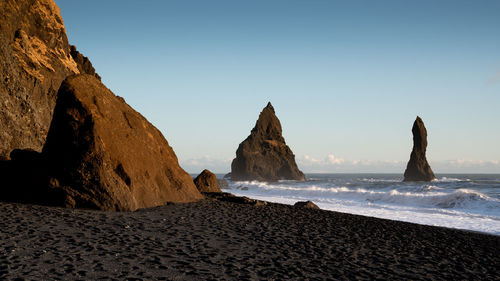 Rocks on beach against clear sky