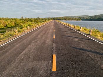 Empty road by lake 