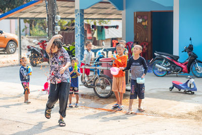 Rear view of people with umbrella on road