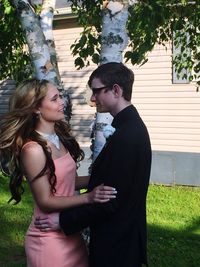 Young couple standing in front of house