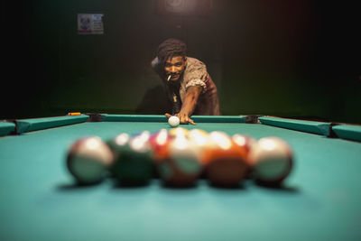 A young man playing pool. 