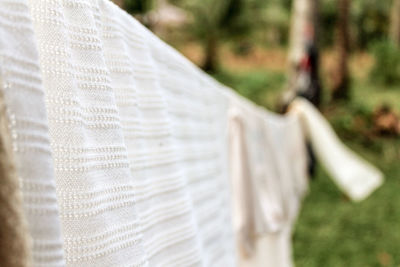 Close-up of textiles hanging on clothesline in yard