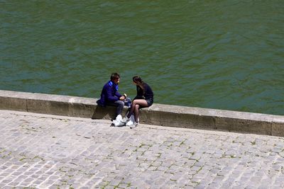 High angle view of people sitting on shore