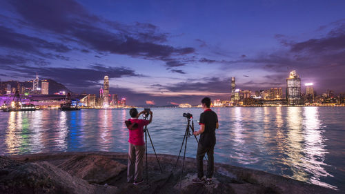 People standing in illuminated city at night