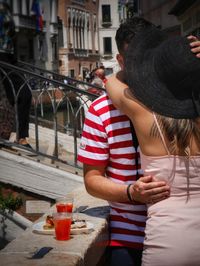 Midsection of woman standing with umbrella in city