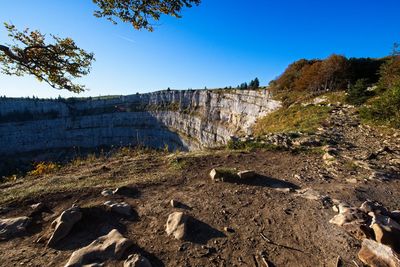 Rock formations on landscape against clear blue sky