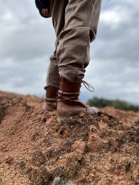 Low section of man standing on rock