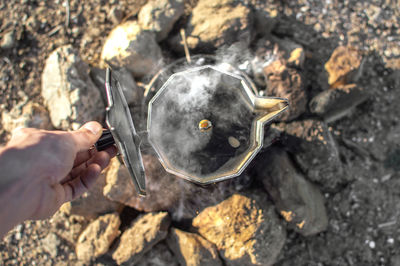 High angle view of hand holding rock