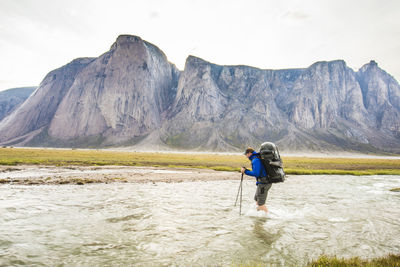 Rear view of man on mountain against sky