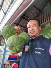 Portrait of man standing at market stall