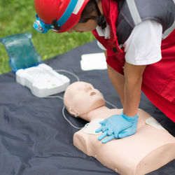 Healthcare worker practicing on cpr dummy at park