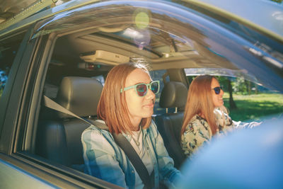 Friends enjoying road trip while traveling in car