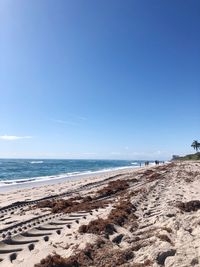 Scenic view of beach against clear blue sky