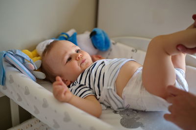 Father changing diapers of cute little baby boy