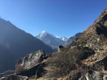 Scenic view of snowcapped mountains against clear blue sky