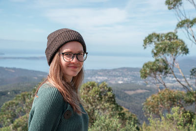Portrait of smiling young woman wearing hat standing in water