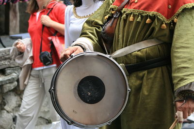 Midsection of drummer standing by women