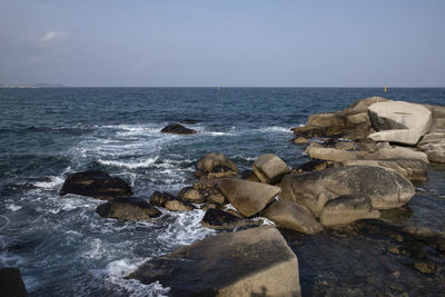 Rocks on beach against sky