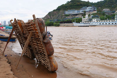 Abandoned boats on shore at beach against sky