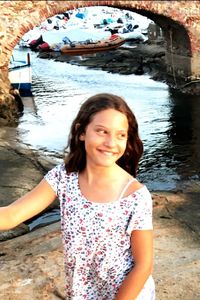 Portrait of smiling young woman standing in water