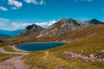 Scenic view of sea and mountains against blue sky