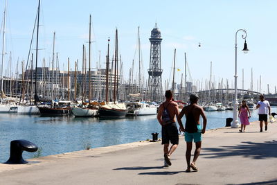 Friends at harbor against sky in city