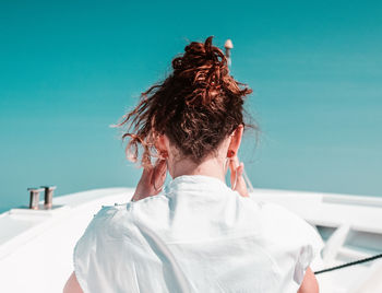 Rear view of woman with umbrella against sky