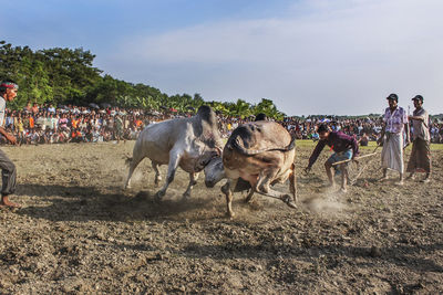 Group of people on field against sky