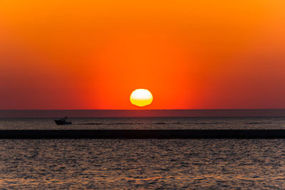 Scenic view of sea against orange sky